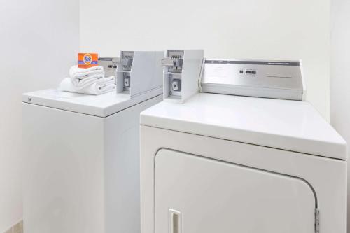 uma máquina de lavar roupa branca num quarto branco em Super 8 by Wyndham Woodstock em Woodstock