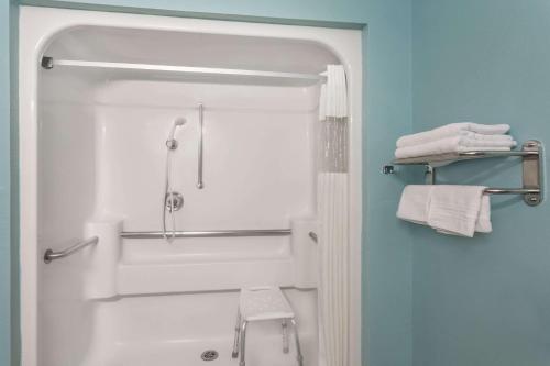 a bathroom with a shower and a toilet and towels at Super 8 by Wyndham Cedar City in Cedar City