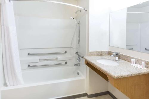 a bathroom with a tub and a sink and a shower at Super 8 by Wyndham Bend in Bend