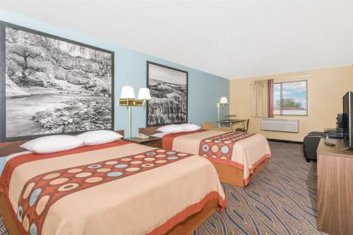 ein Hotelzimmer mit 2 Betten und einem TV in der Unterkunft Super 8 by Wyndham Cedar City in Cedar City