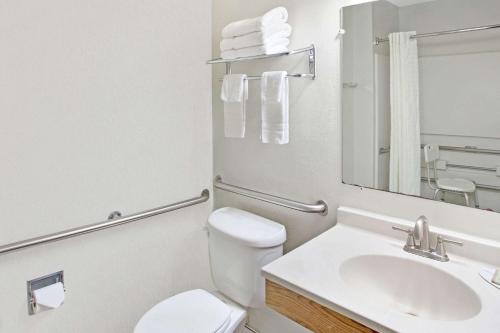 a bathroom with a toilet sink and a mirror at Super8 by Wyndham NEARBY Clearwater St Petersburg International Airport in Clearwater