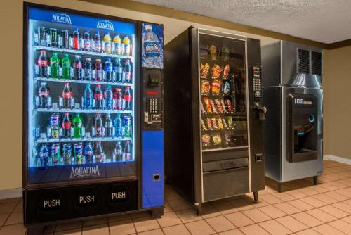 a soda machine next to a vending machine with soda bottles at Super 8 by Wyndham Grants in Grants