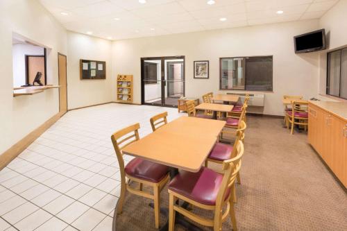 a dining room with tables and chairs and a tv at Super 8 by Wyndham Bend in Bend