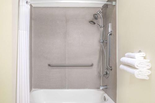 a bathroom with a shower and a bath tub with towels at Days Inn by Wyndham Kingman East in Kingman