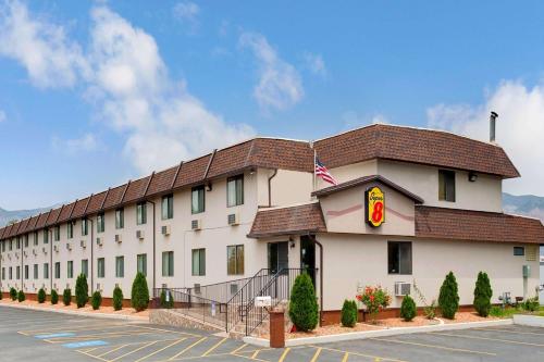 a large white building with a red roof at Super 8 by Wyndham Ogden, Utah in Ogden