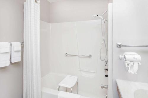 a white bathroom with a shower and a sink at Super 8 by Wyndham Watseka in Watseka