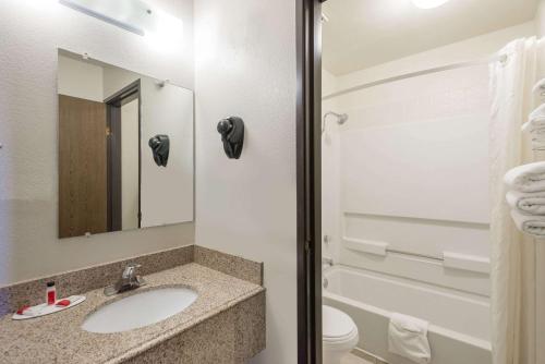 a bathroom with a sink and a toilet and a mirror at Super 8 by Wyndham Tucumcari in Tucumcari