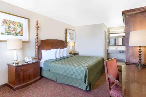 a hotel room with a bed and a table and lamp at Days Inn by Wyndham Kingman East in Kingman