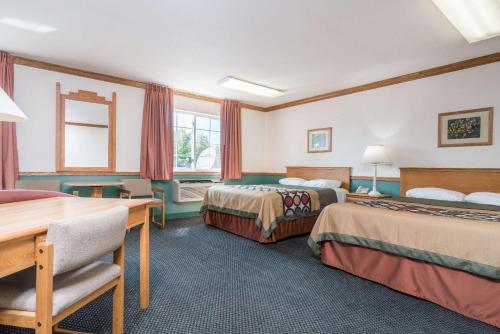 a hotel room with two beds and a desk at Super 8 by Wyndham Sheldon in Sheldon