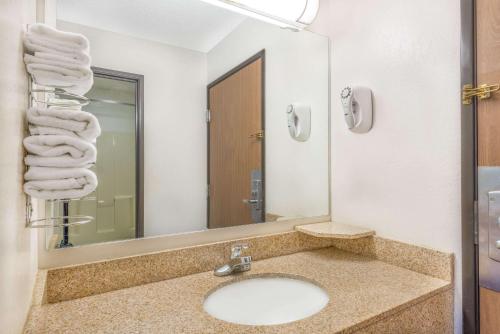 La salle de bains est pourvue d'un lavabo, d'un miroir et de serviettes. dans l'établissement Super 8 by Wyndham Vincennes, à Vincennes