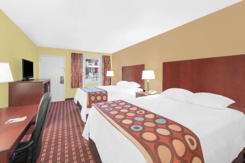 a hotel room with two beds and a desk at Super 8 by Wyndham Kerrville TX in Kerrville