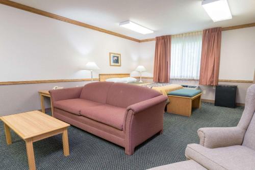 a hotel room with a couch and a bed at Super 8 by Wyndham Sheldon in Sheldon