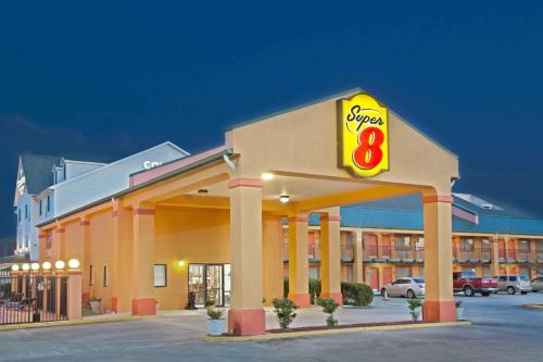 コビントンにあるSuper 8 by Wyndham Covingtonの表面に看板を貼ったガソリンスタンド