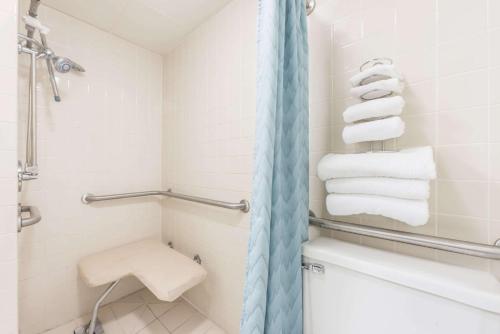 een badkamer met een douche, een toilet en handdoeken bij Super 8 by Wyndham Du Quoin in Du Quoin