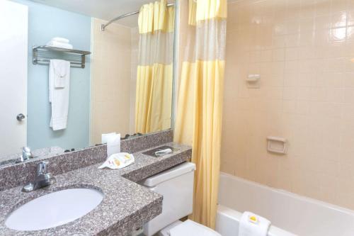 a bathroom with a sink and a toilet and a tub at Days Inn by Wyndham Portage in Portage
