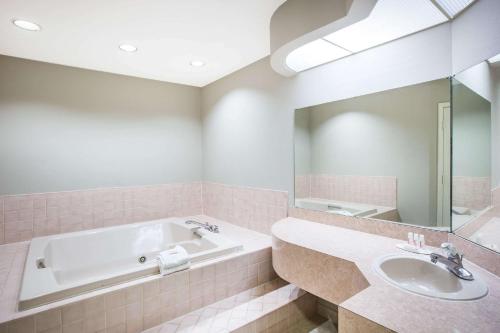 a pink bathroom with a tub and a sink at Super 8 by Wyndham Oxford in Oxford