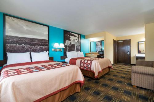 a hotel room with two beds and a chair at Super 8 by Wyndham Rochester Mayo Clinic Area in Rochester