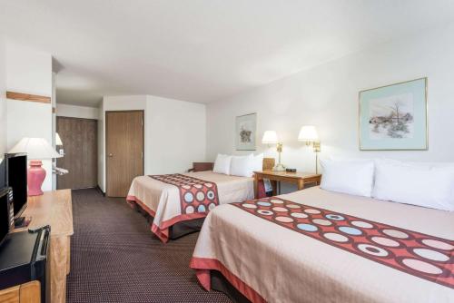 a hotel room with two beds and a flat screen tv at Super 8 by Wyndham Du Quoin in Du Quoin