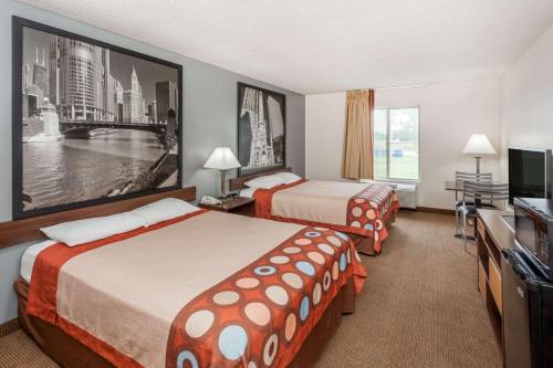ein Hotelzimmer mit 2 Betten und einem Flachbild-TV in der Unterkunft Super 8 by Wyndham Pekin/Peoria Area in Pekin