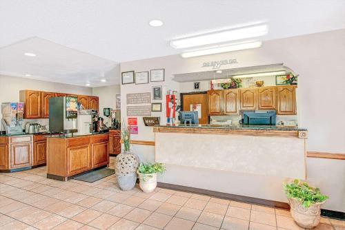 a large kitchen with wooden cabinets and a counter at Super 8 by Wyndham San Antonio/Fiesta in San Antonio