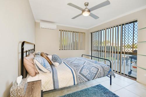 una camera con letto e ventilatore a soffitto di Woomba1 a Mooloolaba