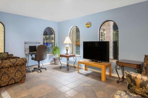 a living room with a flat screen tv and a couch at Days Inn Windcrest by Wyndham San Antonio in San Antonio