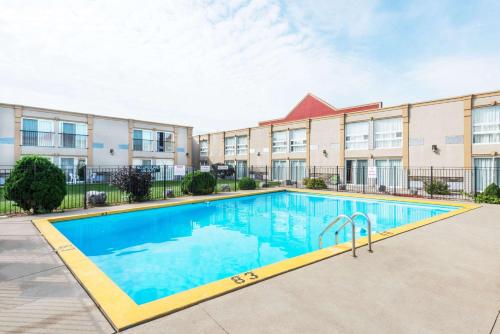 a swimming pool in front of a building at Super 8 by Wyndham Cambridge/Kitchener/Waterloo Area in Cambridge