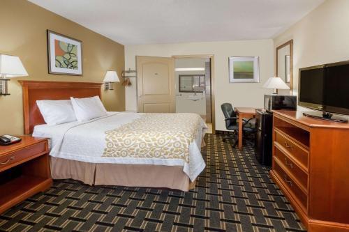 a hotel room with a bed and a flat screen tv at Days Inn by Wyndham Kent - Akron in Kent