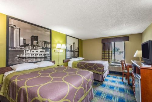 En eller flere senge i et værelse på Super 8 by Wyndham Sulphur Lake Charles