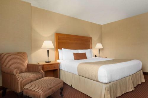a hotel room with a bed and a chair at Days Inn by Wyndham Edmonton Downtown in Edmonton