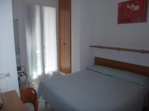 una camera da letto con un letto blu e una finestra di Hotel Adriana a Laigueglia