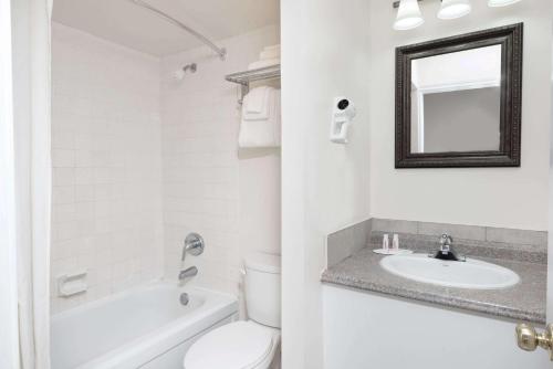 a white bathroom with a toilet and a sink at Super 8 by Wyndham Cambridge/Kitchener/Waterloo Area in Cambridge