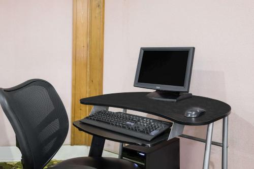 a desk with a computer monitor and a keyboard at Days Inn by Wyndham Walterboro in Walterboro