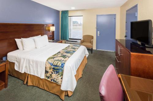 a hotel room with a bed and a flat screen tv at Days Inn by Wyndham Walterboro in Walterboro