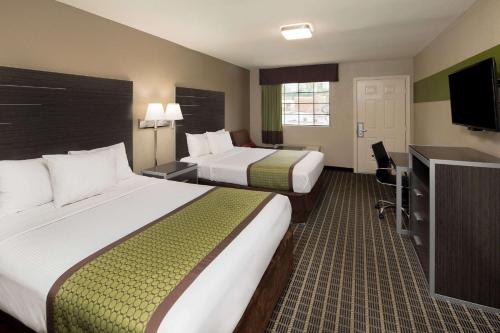 um quarto de hotel com duas camas e uma televisão de ecrã plano em Days Inn & Suites by Wyndham Athens em Athens