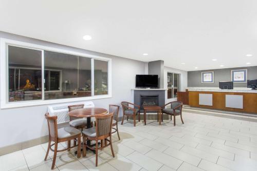 a living room with a table and chairs and a fireplace at Travelodge by Wyndham Williams Grand Canyon in Williams