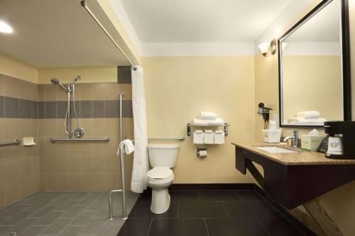 a bathroom with a toilet and a shower and a sink at Days Inn by Wyndham Fultondale in Fultondale