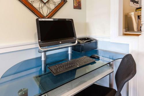 a glass desk with a computer on top of it at Days Inn by Wyndham Kent - Akron in Kent