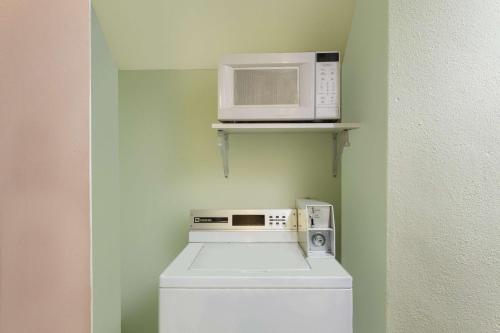 a microwave sitting on a shelf above a washing machine at Travelodge by Wyndham Williams Grand Canyon in Williams