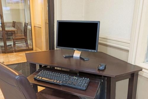 a computer monitor and keyboard on a wooden desk at Super 8 by Wyndham Cambridge/Kitchener/Waterloo Area in Cambridge