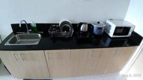 a kitchen counter with a sink and a microwave at Rm Staycation TaalView Smdc in Tagaytay