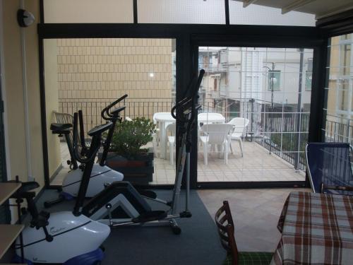 una palestra con 2 cyclette e un balcone di Hotel Adriana a Laigueglia