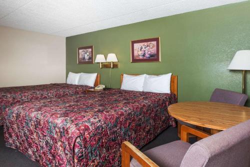 a hotel room with a bed and a table at Days Inn by Wyndham New Market I-81 in New Market