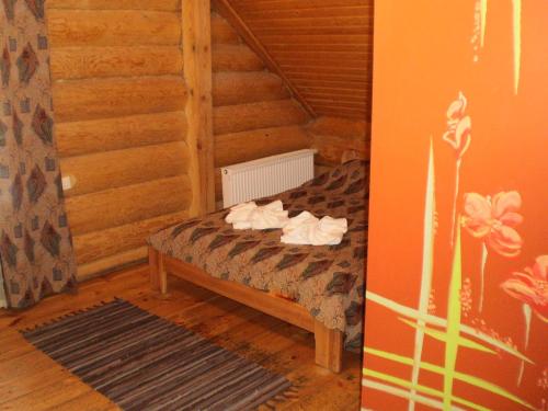 une chambre avec un lit dans une pièce en bois dans l'établissement Visdari, à Rumbula