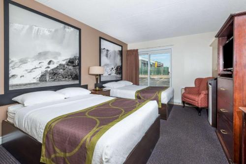 a hotel room with two beds and a tv at Super 8 by Wyndham Cambridge/Kitchener/Waterloo Area in Cambridge