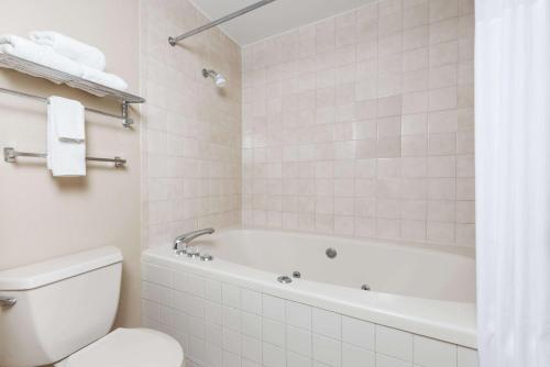 a white bathroom with a tub and a toilet at Days Inn by Wyndham New Market I-81 in New Market
