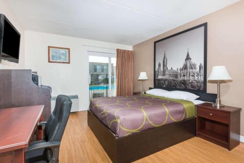 a hotel room with a bed and a desk at Super 8 by Wyndham Cambridge/Kitchener/Waterloo Area in Cambridge