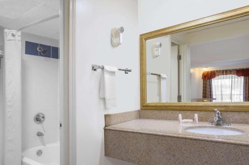 a bathroom with a sink and a mirror at Super 8 by Wyndham Port Royal/Beaufort in Port Royal