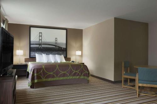 a hotel room with a bed and a bridge at Super 8 by Wyndham Manistee in Manistee