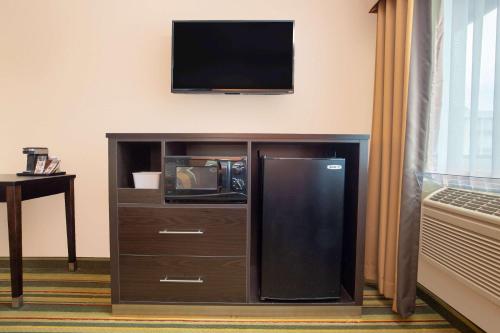 a entertainment center with a tv and a refrigerator at Super 8 by Wyndham Chico in Chico